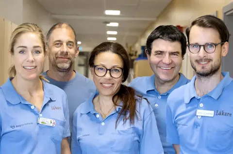 Fem läkare i blå vårdkläder.